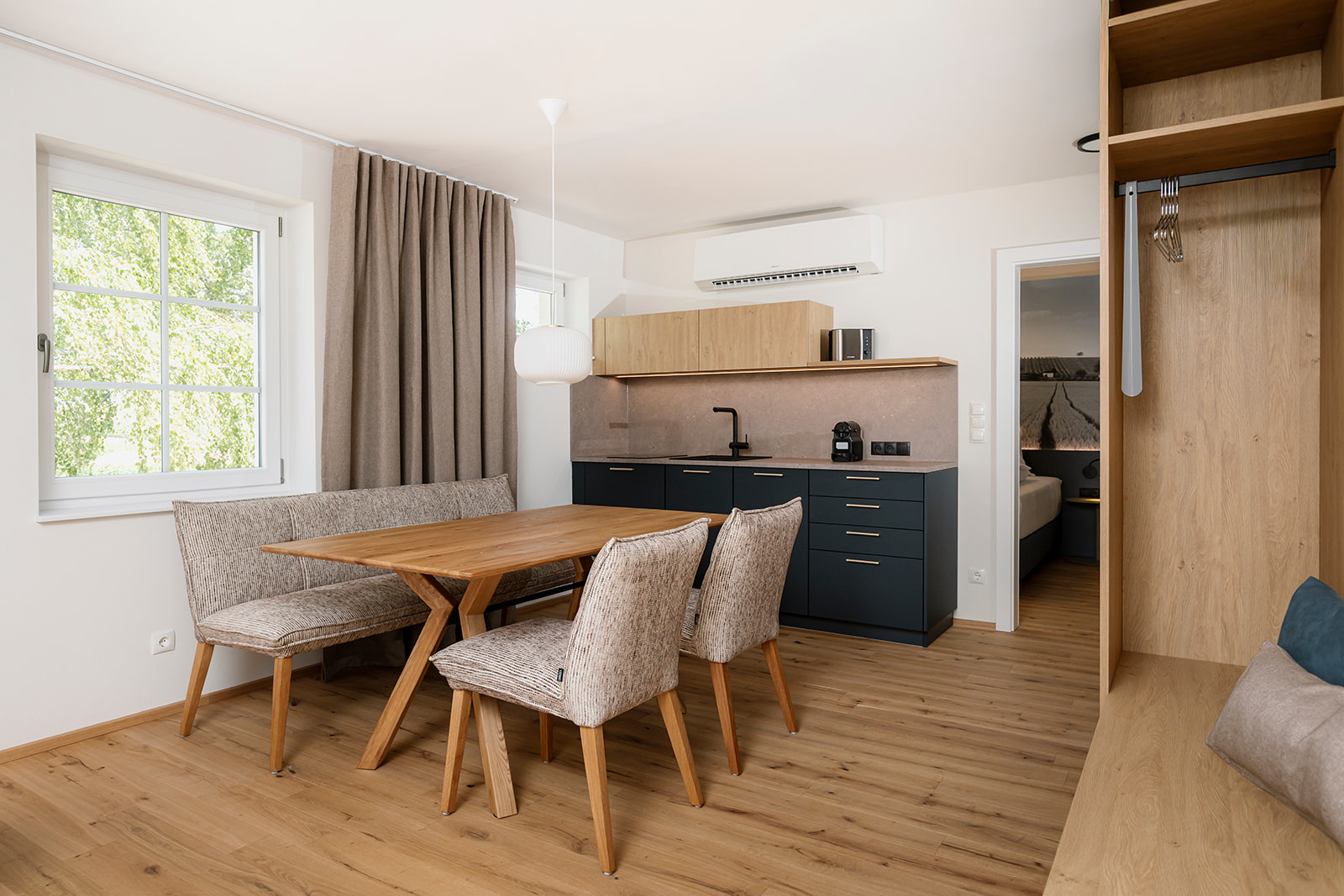Helle Wohnküche mit Essbereich, Küchenzeile und Garderobe in einem Appartement des Zollquartiers